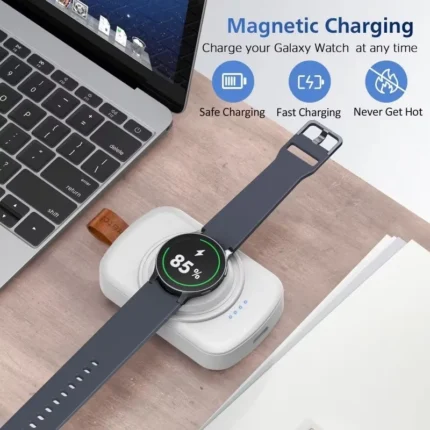 Magnetic wireless smartwatch charger power bank with keychain clip and smartwatch resting on charging surface.