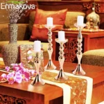 Wedding table centerpiece candle holder with metallic column stand for pillar candles and floral arrangements.