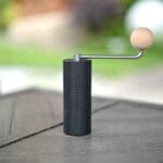Manual hand coffee grinder with stainless steel burr core and smooth wooden handle.